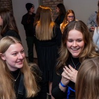 Group of three girls laugh and talk together